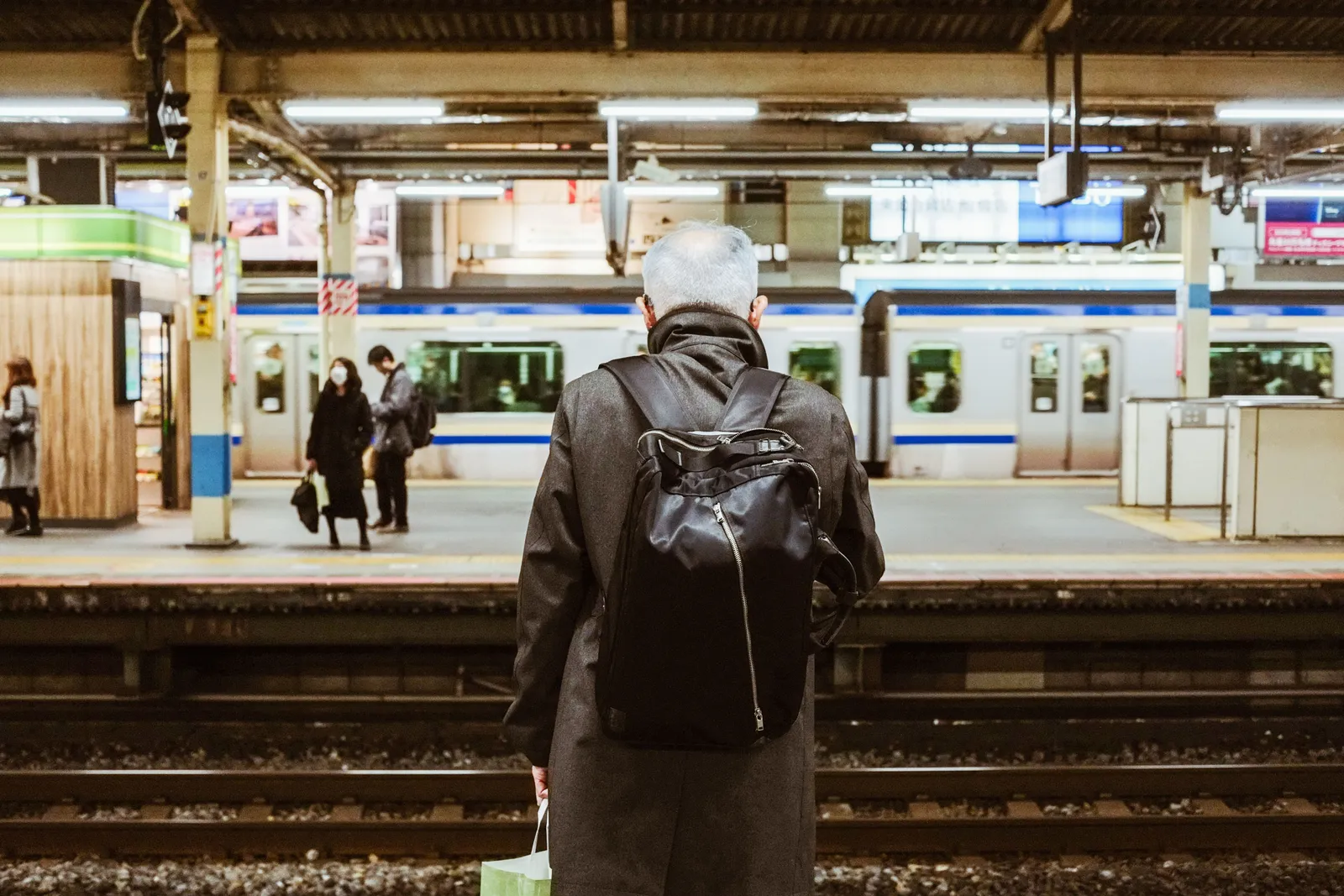 נוסע עם תיק גב בלבד ממתין לרכבת ברציף בתחנה ביפן