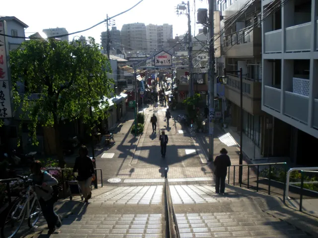 רחוב חנויות צר היורד במדרגות, עם עוברי אורח מעטים