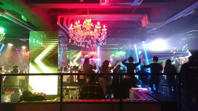 רחבת ריקודים עם אורות ורודים וכחולים, נברשת גדולה וקהל רוקד