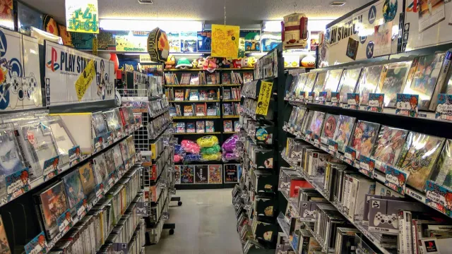 מעבר צר בחנות משחקים עם מדפים עמוסים מהרצפה לתקרה