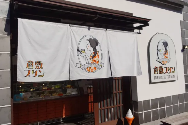 וילון בד לבן עם איור אישה בקימונו, מעל חלון הגשה ומקרר תצוגה